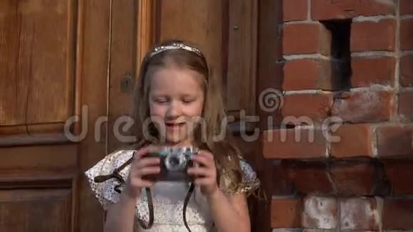 可爱的小女孩用复古相机拍摄她周围的一切视频的预览图
