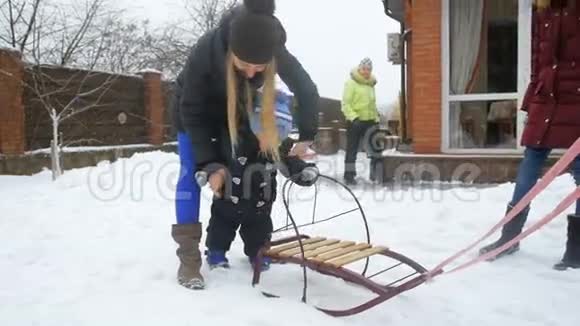 小男孩在自家后院玩雪橇的慢动作视频视频的预览图