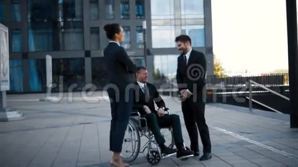 轮椅上残疾的白种人及其商业同事视频的预览图