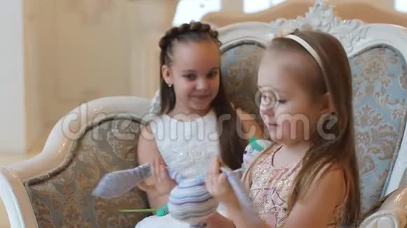 穿着漂亮衣服的小女孩正在看礼物视频的预览图