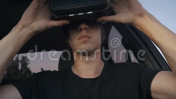 一名男子坐在车上戴耳机的特写镜头获得使用VR耳机的经验视频的预览图
