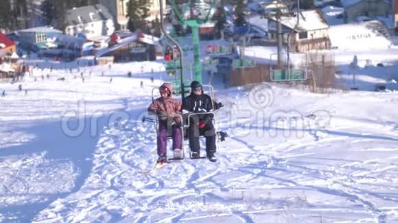 阳光明媚的一天两名滑雪者乘坐滑雪电梯3840x2160视频的预览图