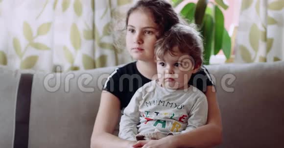 一个孩子坐在他妹妹的怀里神情专注4k视频的预览图