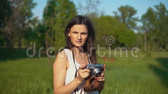 年轻女性摄影师在户外用相机拍照视频的预览图