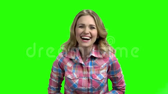 年轻可爱的女孩在绿色的屏幕上笑视频的预览图