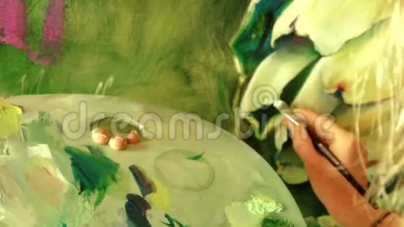年轻女画家用油画调色板画一幅画视频的预览图