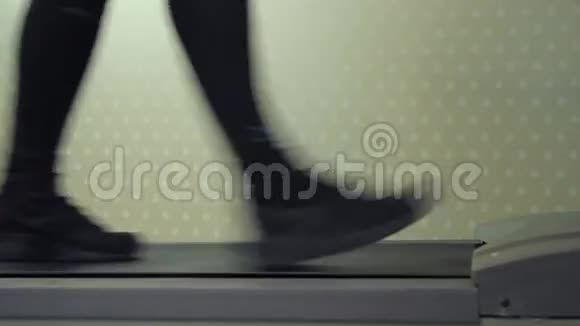 运动员脚在跑步机上行走侧景视频的预览图
