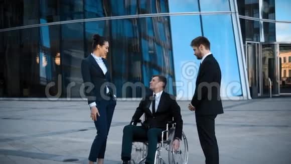 坐轮椅的残疾商人和他的两个同事之间有积极的对话视频的预览图