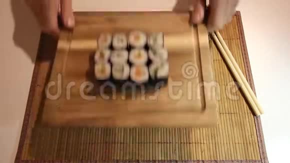 服务员的手正把桌子上放着寿司服务员的手正拿着寿司离开桌子视频的预览图