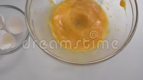 用电动搅拌器将新鲜鸡蛋倒入碗中近距离观看视频的预览图