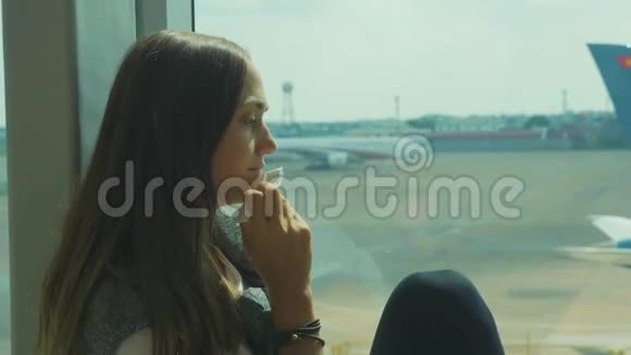 年轻悲伤的女人正在机场哭泣背景是飞机视频的预览图