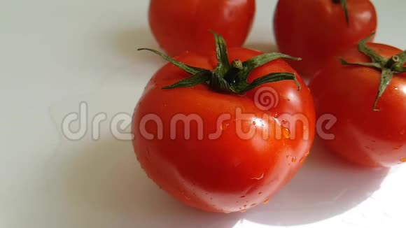 新鲜的西红柿水在白色背景下缓慢下降视频的预览图