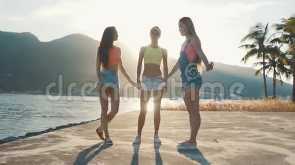 日落时分三个朋友在海滩上跳跃视频的预览图