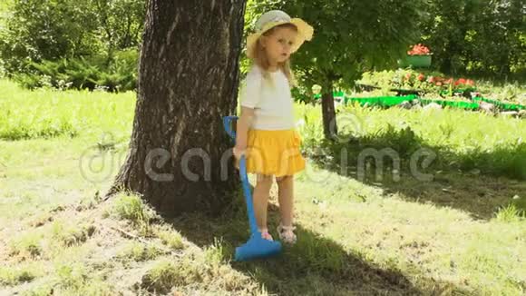 一个小女孩在夏天耙草视频的预览图