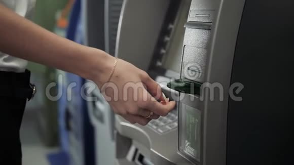 接近一名使用银行机器的妇女的手使用信用卡业务提款美元欧元视频的预览图