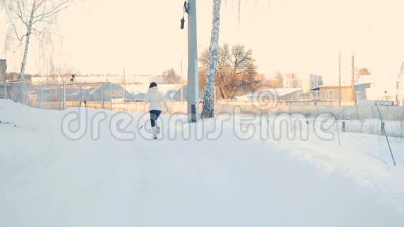 穿着白大褂的女人在雪地公园慢动作跑视频的预览图