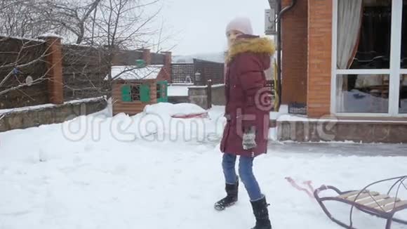 快乐少女在家后院打雪球的慢动作视频视频的预览图