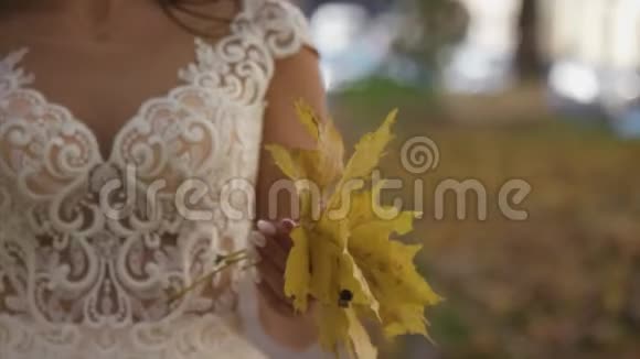身着白色婚纱的年轻新娘手中捧着美丽的新娘花束把一大堆新鲜的白色视频的预览图