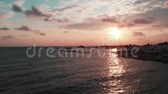 日落时用无人机拍摄码头日落时海浪的海景视频的预览图