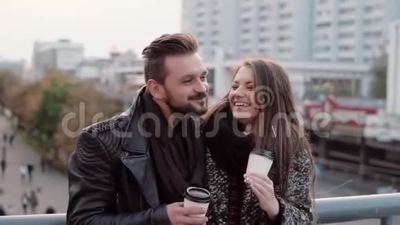 两个快乐的年轻人玩得很开心英俊的年轻人和漂亮的女孩开心地笑着手里拿着外卖咖啡慢动作视频的预览图