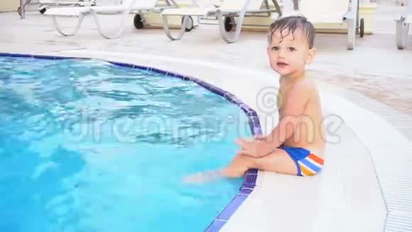 小男孩正坐在度假村的池边视频的预览图