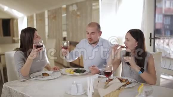朋友们在明亮通风的餐厅用餐前品尝红酒视频的预览图