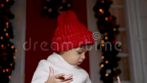 孩子们穿着白色毛衣和红色帽子站在雪地里的门廊台阶上视频的预览图