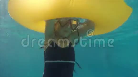 有充气橡皮圈的小女孩在户外游泳池里玩得开心视频的预览图