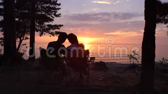一对夫妇晚上坐在露营地视频的预览图