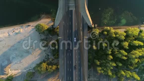 4的空中无人机镜头飞越莫斯科夫斯基大桥塔台在马路上用汽车垂直射击日落时分视频的预览图