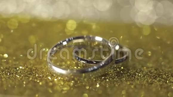 婚礼银环躺在闪亮的光泽表面光芒四射特写视频的预览图