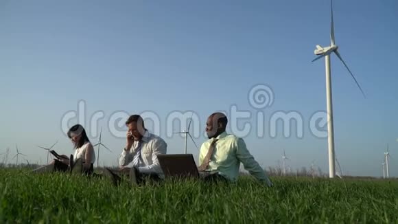 一群穿着西装坐在草地上工作的人视频的预览图