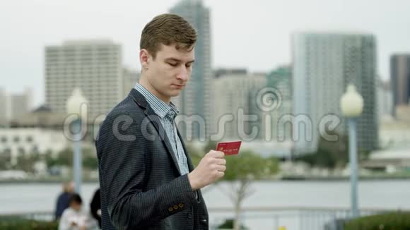 有魅力的家伙在街上盯着信用卡视频的预览图