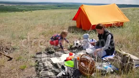 父母和孩子野餐他们将在帐篷里过夜旅行妇女和儿童放松视频的预览图