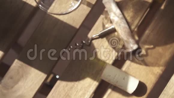 在桌子上阳光透过瓶子慢慢地把酒倒在杯子里视频的预览图