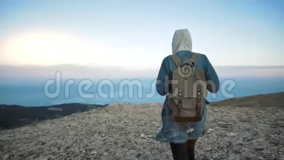 女旅行者带着背包步行和欣赏山景视频的预览图
