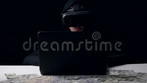 黑客在黑暗的房间里工作虚拟现实的头盔他算钱网络犯罪视频的预览图