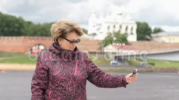 60岁的成年女性使用智能手机拍照视频的预览图