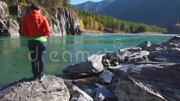 一个女人站在河边看山视频的预览图