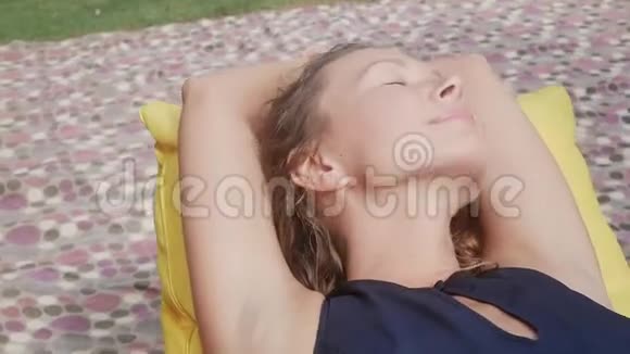 女人在草地上的空地上的一张包椅上放松视频的预览图