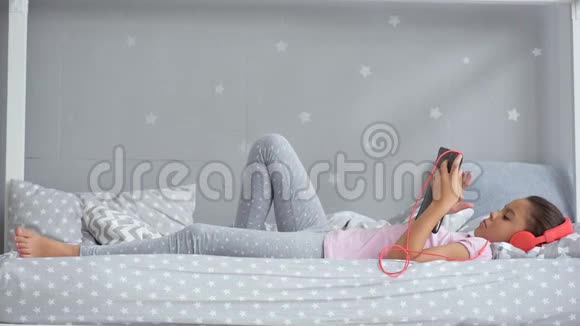 在床上听音乐的漂亮小女孩视频的预览图