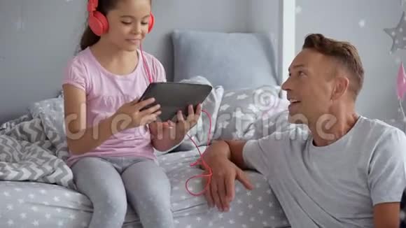 积极的父亲和他的小女儿唱歌视频的预览图
