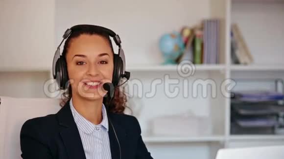 一个在办公室里用耳机接电话的有趣女孩视频的预览图