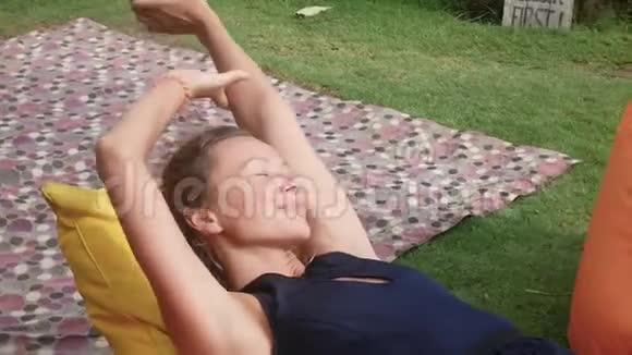 女人在草地上的空地上的一张包椅上放松视频的预览图