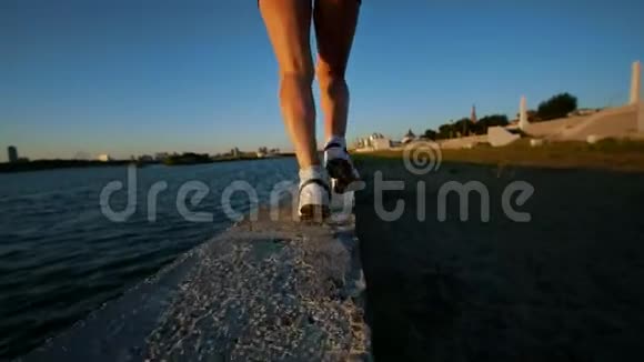 美丽的运动女人在河边跑步视频的预览图