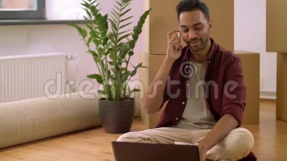 有笔记本电脑和盒子的男人在家打电话视频的预览图