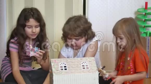 快乐的孩子女孩在家玩娃娃屋和泰迪熊有趣可爱的孩子在孩子们的房间里玩得很开心视频的预览图