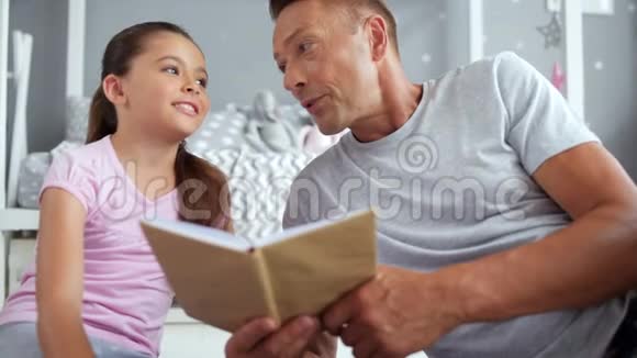 积极的小女孩和她的父亲在看书视频的预览图