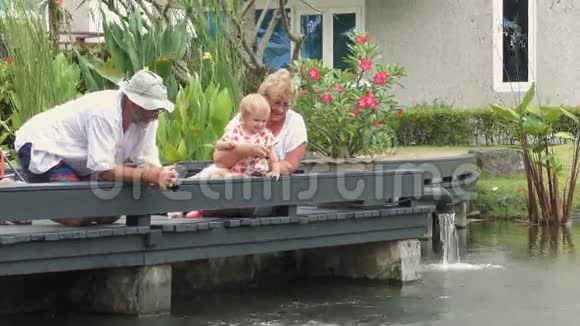 祖父母带着孩子在池塘里喂鱼视频的预览图