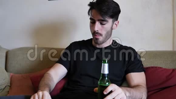 年轻人在沙发上喝啤酒吃东西视频的预览图
